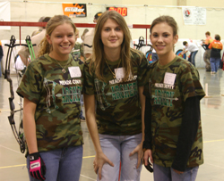 3 young female students at archery tournament